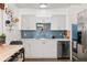 Bright kitchen featuring white cabinets, stainless steel appliances, and blue subway tile backsplash at 3100 W 94Th Ave, Westminster, CO 80031