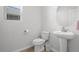 Clean, simple bathroom features a pedestal sink, round mirror, and toilet with tiled flooring at 7315 Blue Water Dr, Castle Rock, CO 80108