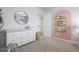 Well-lit bedroom featuring a dresser, a decorative arch, and carpet flooring at 7315 Blue Water Dr, Castle Rock, CO 80108