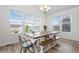Bright dining room with a wooden table and chairs featuring large windows and natural light at 7315 Blue Water Dr, Castle Rock, CO 80108