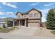 Inviting two-story home with neutral siding, a spacious driveway, and a newly planted tree at 7315 Blue Water Dr, Castle Rock, CO 80108