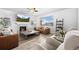 Bright living room with a fireplace, plush seating, and large windows overlooking the backyard at 7315 Blue Water Dr, Castle Rock, CO 80108