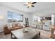 Spacious living room with a large window, a ceiling fan, and views into the kitchen at 7315 Blue Water Dr, Castle Rock, CO 80108
