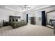 Spacious main bedroom featuring a wooden bed frame, tray ceiling, and a ceiling fan at 7315 Blue Water Dr, Castle Rock, CO 80108