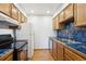 Galley kitchen with blue tile backsplash and wood cabinets at 14465 E 1St Dr # C7, Aurora, CO 80011