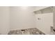 Bright laundry room with marble tile flooring, storage shelf, and white walls at 577 Nightsky St, Erie, CO 80516
