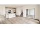 Open-concept living area flows into kitchen with hardwood floors and a sliding glass door at 577 Nightsky St, Erie, CO 80516