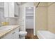 Bright bathroom with granite vanity, tile surround shower/tub and open closet at 7645 E Quincy Ave # 105, Denver, CO 80237