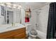 Well-lit bathroom features a vanity with storage, a toilet, and a shower/tub combination at 3613 S Sheridan Blvd # 10, Denver, CO 80235