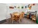 This dining area offers a wooden table with six chairs with a wall decorated with paintings and hanging plants at 3613 S Sheridan Blvd # 10, Denver, CO 80235