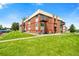 Brick apartment building with well-maintained lawn, lush greenery and a balcony at 3613 S Sheridan Blvd # 10, Denver, CO 80235