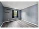 A minimalist bedroom featuring gray walls, wood floors, and a window with natural light at 5250 S Huron Way # 1-204, Littleton, CO 80120