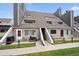 Exterior of townhomes with wood fencing, covered stairs, and well maintained lawn at 5250 S Huron Way # 1-204, Littleton, CO 80120