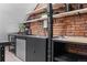 Industrial-style kitchenette with exposed brick and open shelving at 885 S Sherman St, Denver, CO 80209