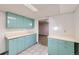 Basement kitchenette featuring blue cabinets, white countertops, and light-colored flooring at 1495 S Chase Ct, Lakewood, CO 80232