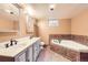 Modern bathroom with double sinks, marble countertops, and tiled tub at 1495 S Chase Ct, Lakewood, CO 80232