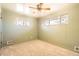 Cozy bedroom with carpet, light green walls, two windows and a ceiling fan with lights at 1495 S Chase Ct, Lakewood, CO 80232