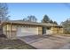 Exterior view of home with brick siding, a two-car garage and driveway at 1495 S Chase Ct, Lakewood, CO 80232