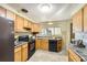 Well-lit kitchen features updated appliances and classic wood cabinets at 1495 S Chase Ct, Lakewood, CO 80232