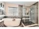 Spa-like bathroom with soaking tub, walk-in shower, and modern fixtures at 14204 W 88Th Dr # C, Arvada, CO 80005