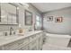 Bright bathroom featuring a double sink vanity, a freestanding tub, and updated fixtures at 6392 S Lafayette St, Centennial, CO 80121