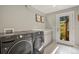 Well-lit laundry room with front load washer/dryer and folding counter at 6392 S Lafayette St, Centennial, CO 80121
