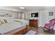Spacious main bedroom featuring wood floors, a large bed, and a seating area at 6392 S Lafayette St, Centennial, CO 80121