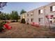 Large fenced backyard with chairs, lush trees, and grill at 2480 W Caithness Pl # 5, Denver, CO 80211