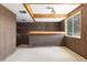 Retro basement bar with bar seating and storage in a paneled room with a window at 7715 Estes Ct, Arvada, CO 80005