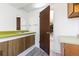 Bright bathroom featuring a vanity with a green countertop, cabinets with chrome hardware and a modern mirror at 7715 Estes Ct, Arvada, CO 80005