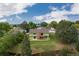 Aerial view of the back of the house highlighting the yard, deck, trees, and chimney at 7715 Estes Ct, Arvada, CO 80005