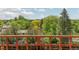 Expansive view of lush greenery and neighboring rooftops from a wooden deck at 7715 Estes Ct, Arvada, CO 80005