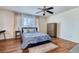 Comfortable bedroom with a ceiling fan, wood floors, and a large window for natural light at 15333 E 98Th Pl, Commerce City, CO 80022