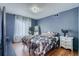 Comfortable bedroom featuring hardwood floors, a modern light fixture, and a neutral color palette at 15333 E 98Th Pl, Commerce City, CO 80022