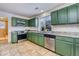 Well-lit kitchen with green cabinets, granite countertops, and modern appliances at 15333 E 98Th Pl, Commerce City, CO 80022