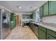 Spacious kitchen featuring green cabinets, stainless steel appliances, and granite countertops at 15333 E 98Th Pl, Commerce City, CO 80022