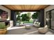 Cozy outdoor seating area with a fireplace, TV, and a view of lush greenery at 1721 Arrowpoint Ct, Franktown, CO 80116