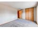 Bedroom featuring a closet with wood doors, a carpeted floor, and neutral walls at 2690 E Otero Pl # 7, Centennial, CO 80122
