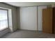 Bedroom featuring a large window with blinds, neutral walls, and a closet at 2690 E Otero Pl # 7, Centennial, CO 80122