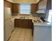 Well-lit kitchen featuring tile floors, wooden cabinets, a white refrigerator, and a white stove at 2690 E Otero Pl # 7, Centennial, CO 80122