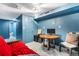 Finished basement area featuring blue walls, a work area and adjacent access to a tiled bathroom at 2730 S Jay St, Denver, CO 80227