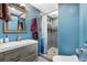 Stylish bathroom featuring a modern vanity, framed mirror, and tiled shower with a glass door at 2730 S Jay St, Denver, CO 80227