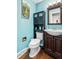 Cozy half-bathroom displaying decorative art, a dark vanity, and blue painted walls at 2730 S Jay St, Denver, CO 80227