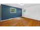 Bright, empty bedroom with hardwood floors, two windows, and blue accent wall at 2730 S Jay St, Denver, CO 80227