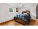Bright bedroom with hardwood floors, ceiling fan, and a comfortable bed with storage drawers at 2730 S Jay St, Denver, CO 80227