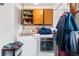 Bright laundry area with appliances, open shelving, and natural wood cabinets at 2730 S Jay St, Denver, CO 80227