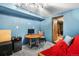 Basement living room with wooden desk, futon, and door to a utility room at 2730 S Jay St, Denver, CO 80227