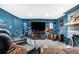 Living room with large TV, comfortable seating, carpeted floor, and decorative wall art at 2730 S Jay St, Denver, CO 80227
