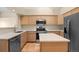 Well-lit kitchen with stainless steel appliances, tile floors, and light wood cabinets at 5946 S Jellison St # F, Littleton, CO 80123