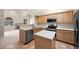 Stylish kitchen with stainless steel appliances, a functional island, and seamless flow to the living area at 5946 S Jellison St # F, Littleton, CO 80123
